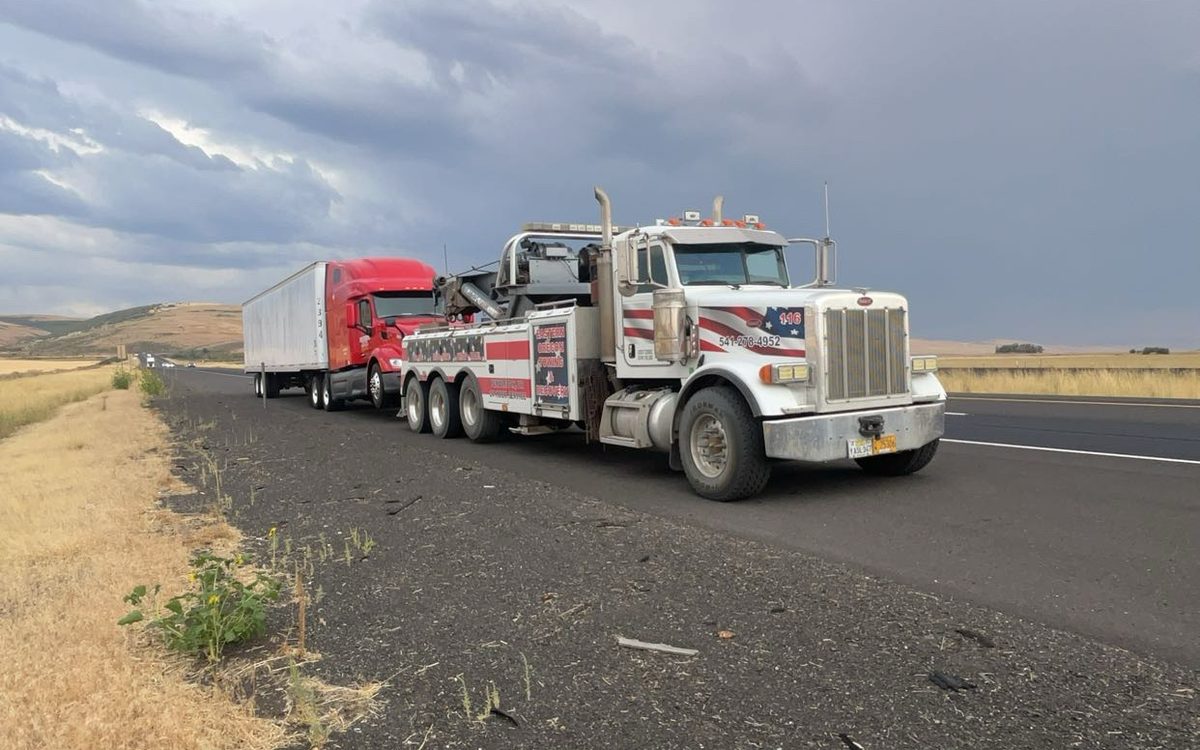 Peterbilt wrecker with a semi on Interstate 84 under a storm
