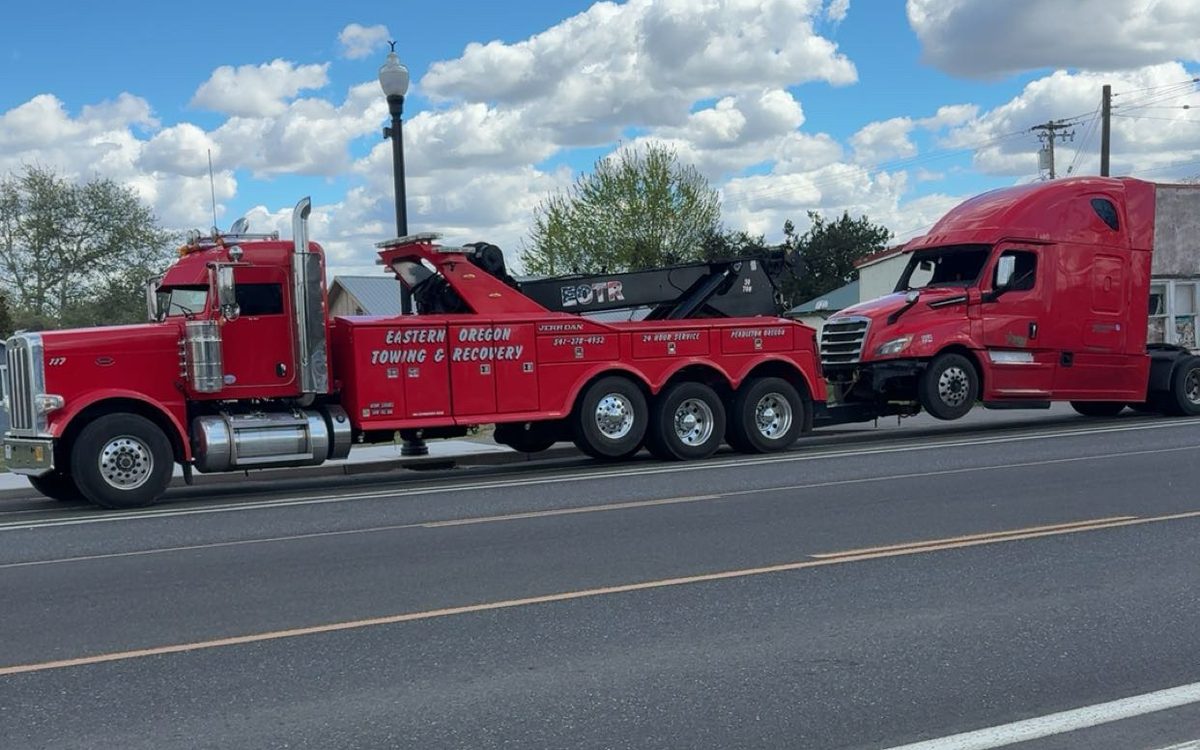 Red Peterbilt heavy wrecker towing a red Freightliner semi in Pendleton, Oregon